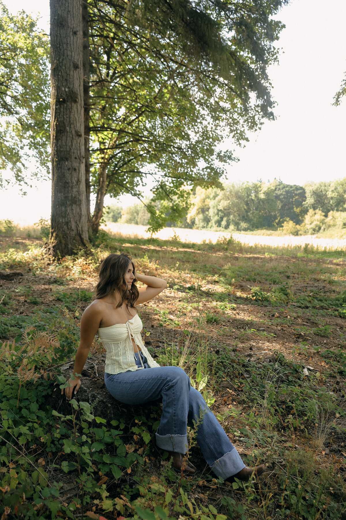 Tall Pine Forest Senior Portrait of Woman in White Dress Standing Beside Tree
