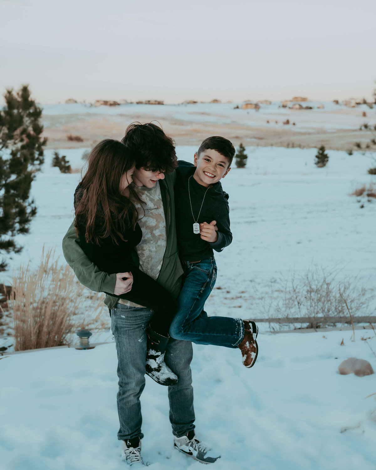 Big brother picking up siblings and laughing