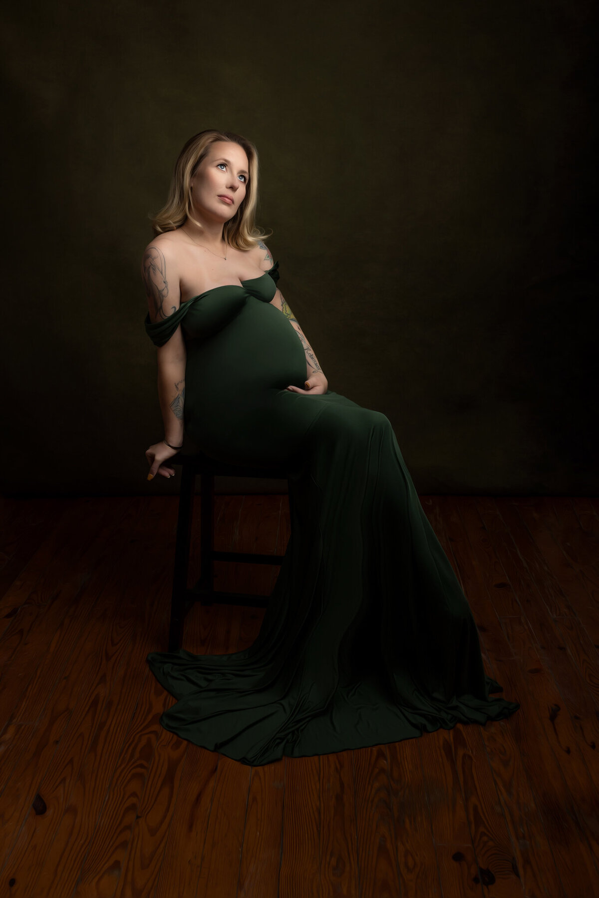 Expectin mother posed on stool in green dress summerville sc maternity