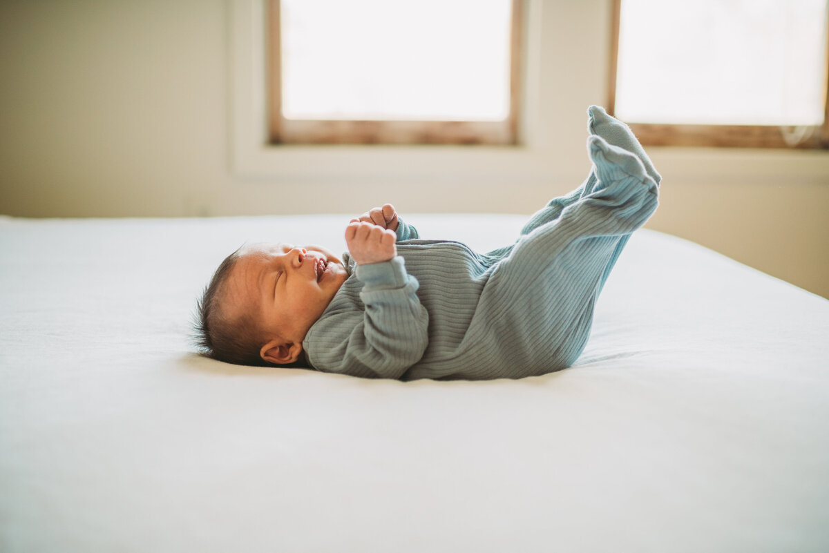 newborn baby laying on bed