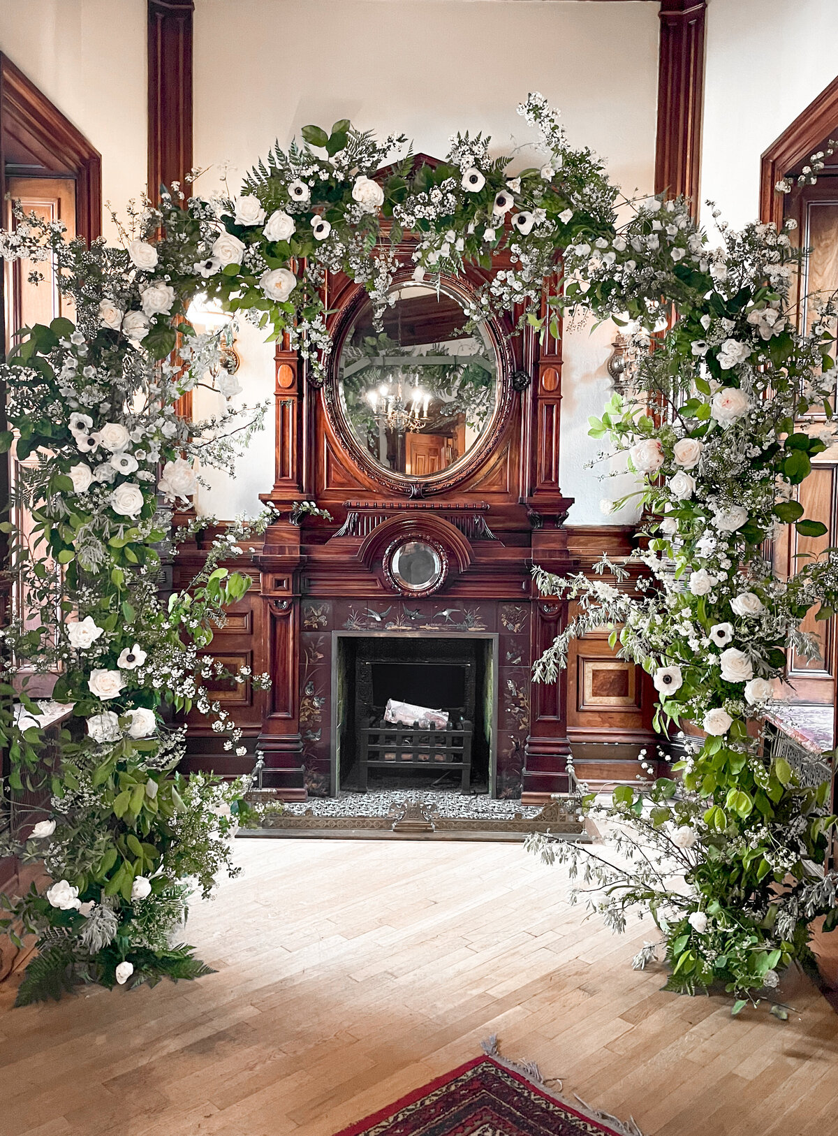 A lush arch white flowers and greenery at a wedding ceremony at Mount Steven.