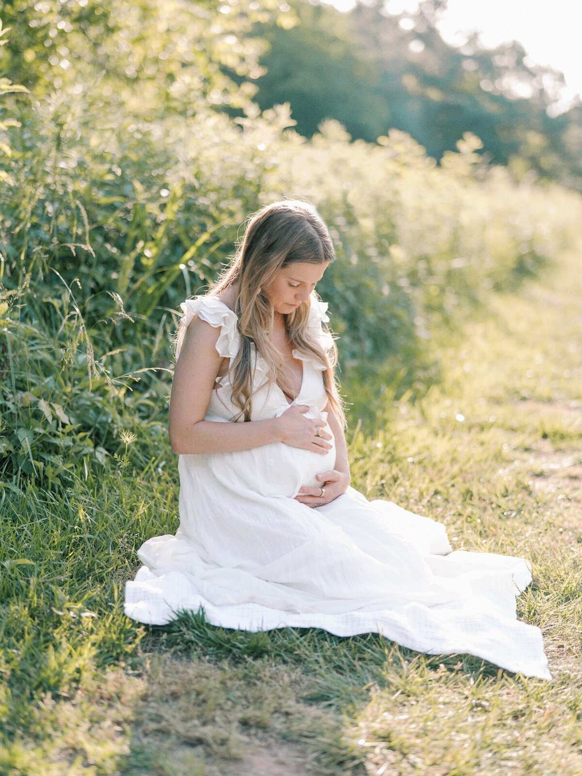 expecting-mom-kneeling-in-tall-grass