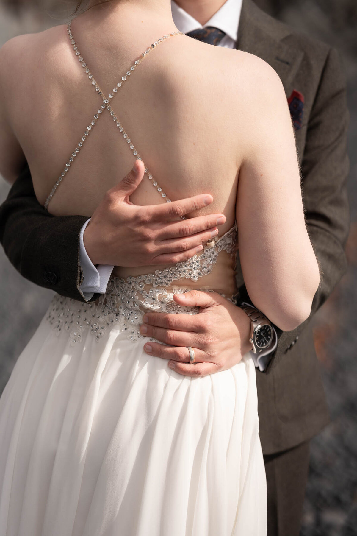 groom-holding-bride-detail-closeup-wedding-dress