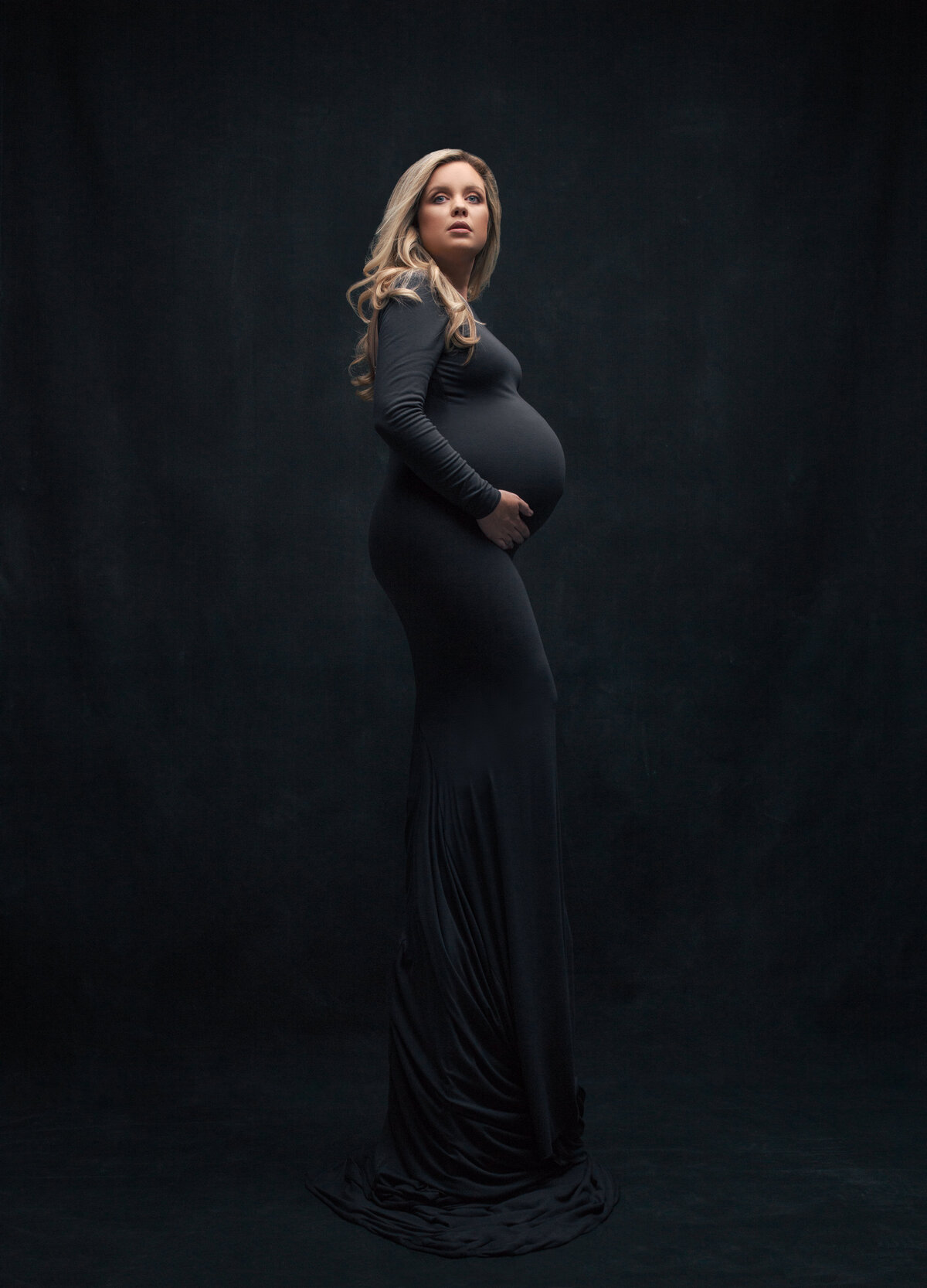 A pregnant woman with her hands under her stomach