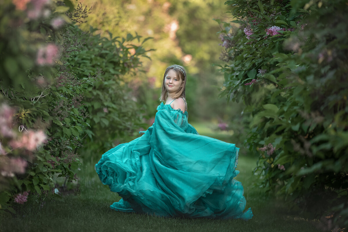 girl in fancy dress twirling in lilacs in outdoor photography session Ottawa Ontario