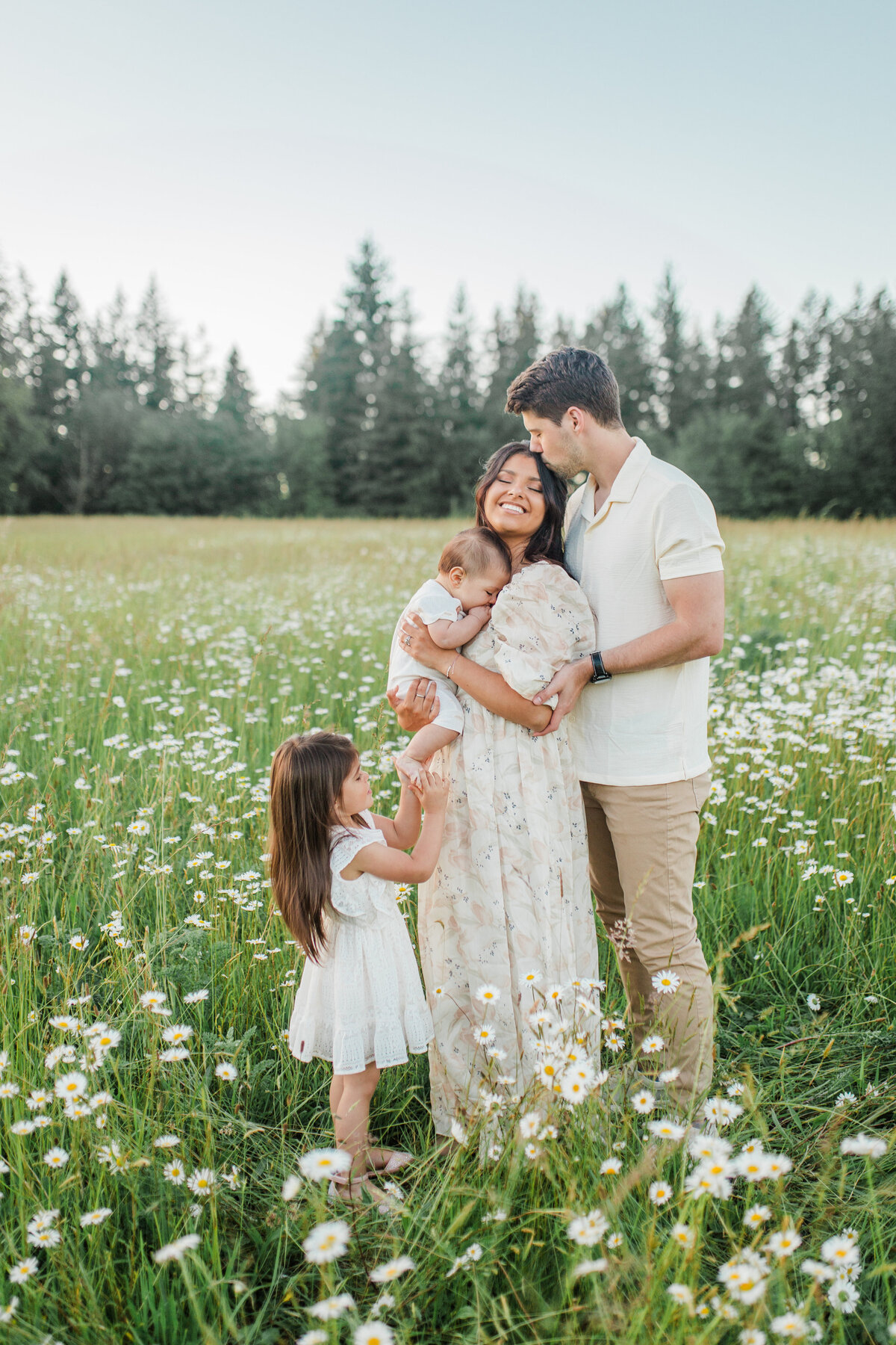 Family with pregnant mother and three children in a field