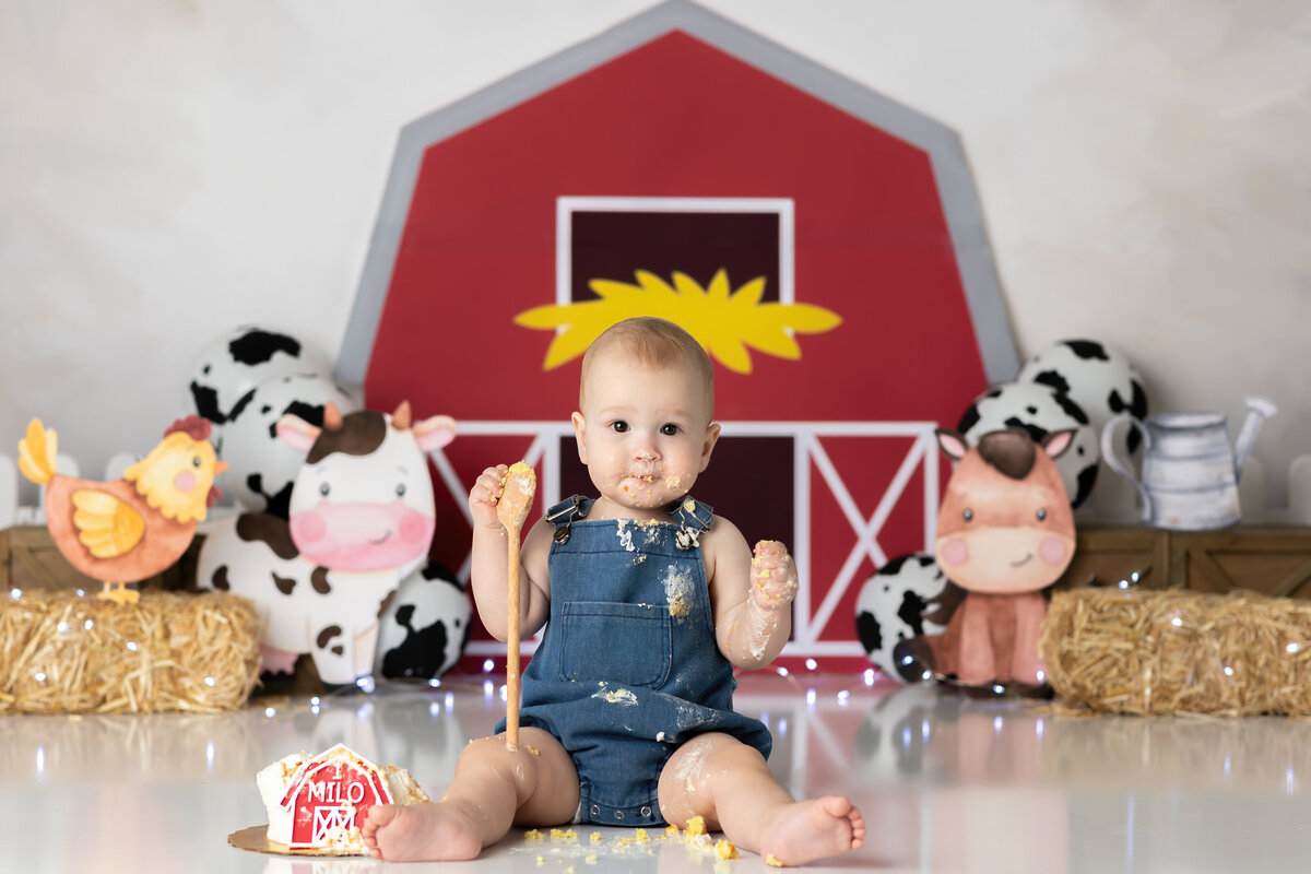 One year old Tampa baby enjoying a personalized luxury cake smash session with playful decorations
