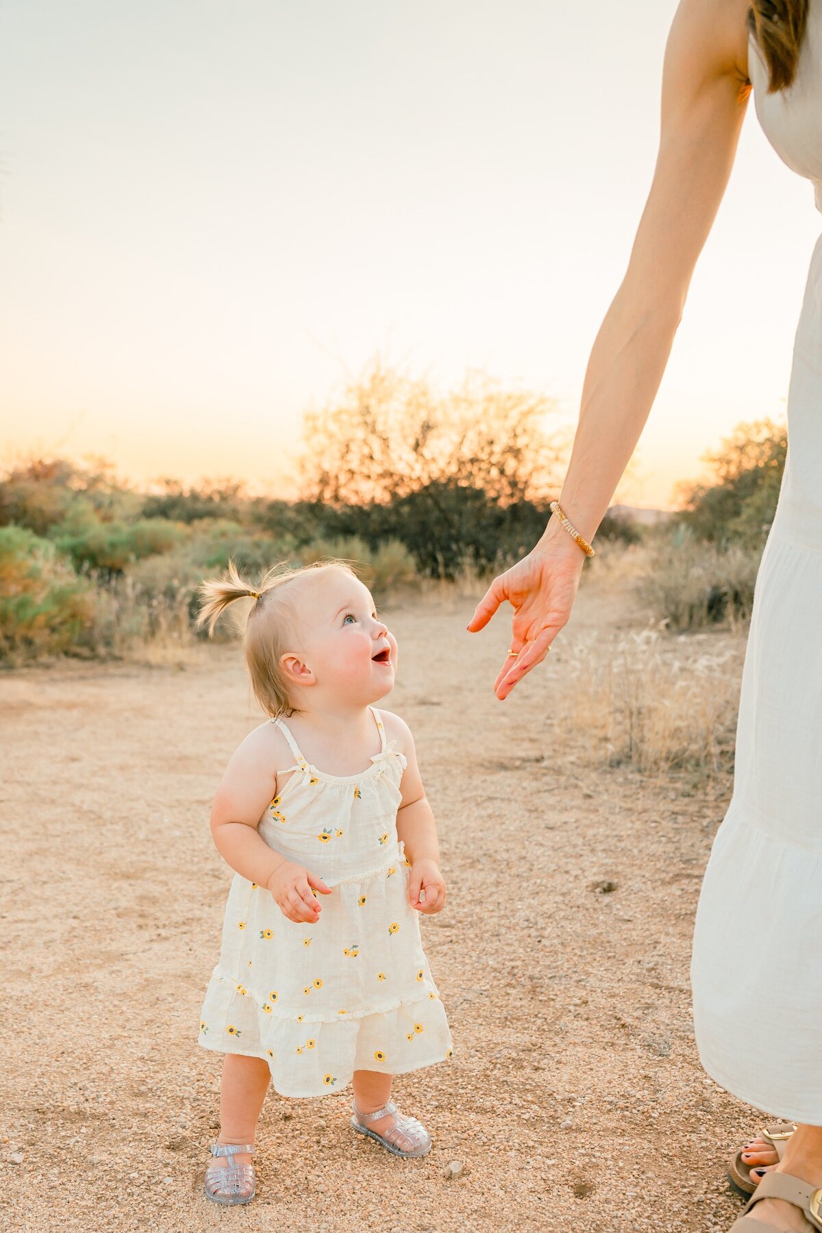 baby looking up at her mom's hand 