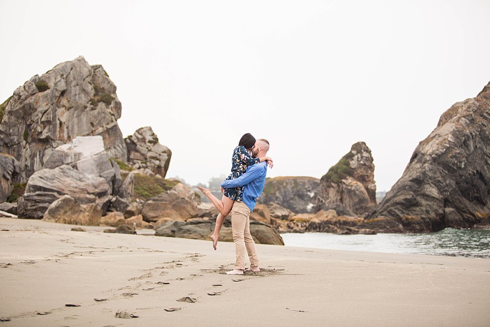 Playful couple kissing on Brookings, Oregon sandy beach