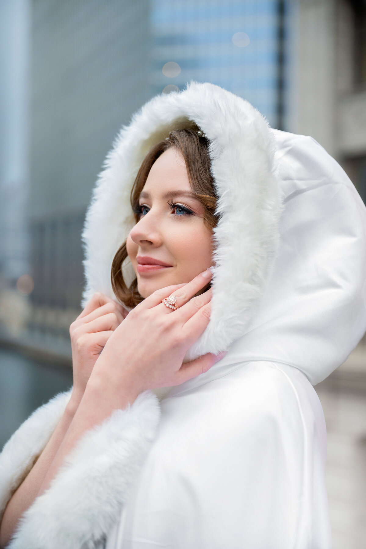 Fine art portrait of bride in the winter covered in white furry hood 