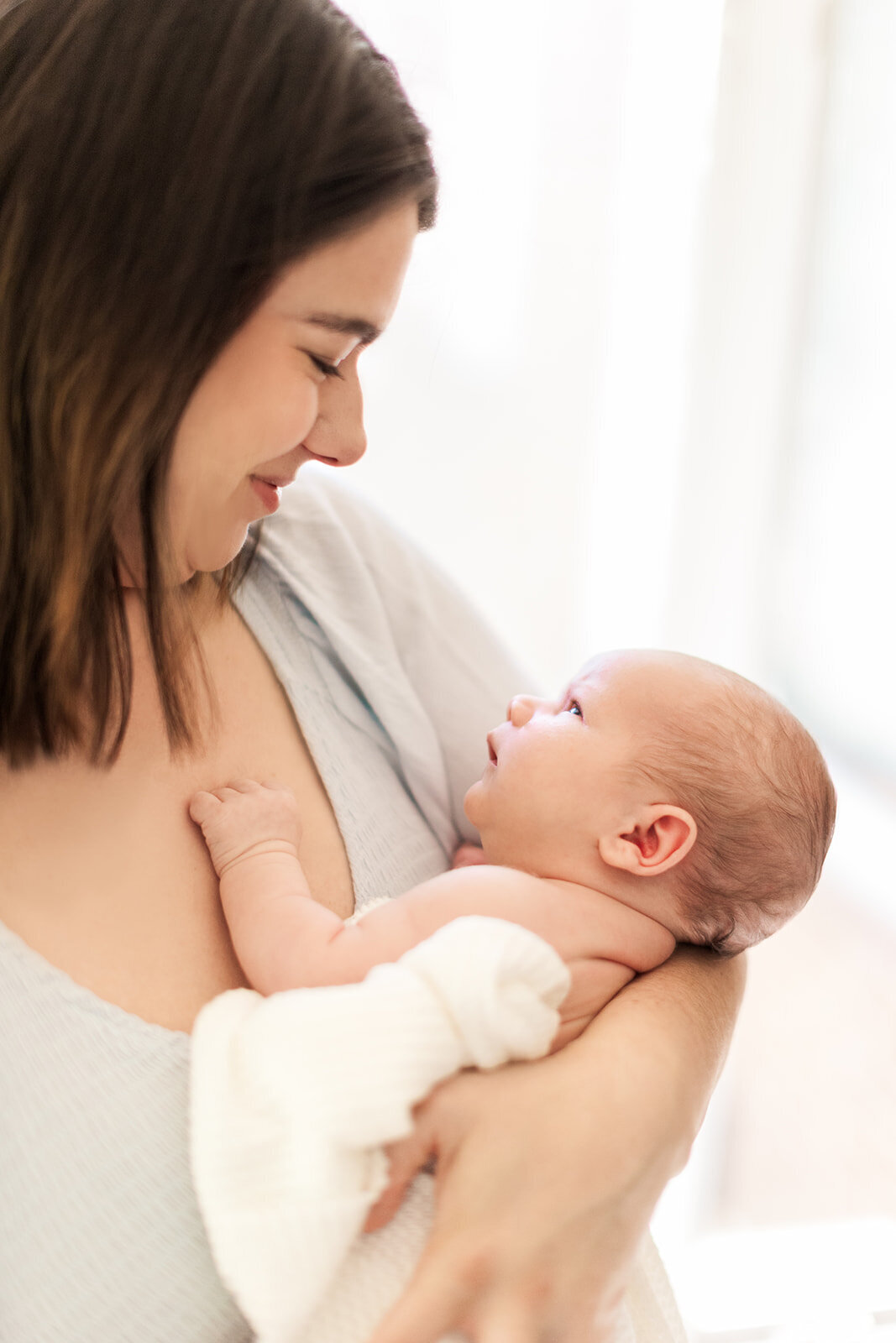 Parents smiling at newborn in cozy nursery
