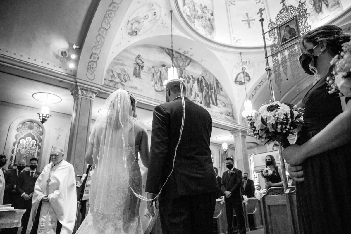 Bride and groom walk around the altar during their Russian Orthodox wedding.