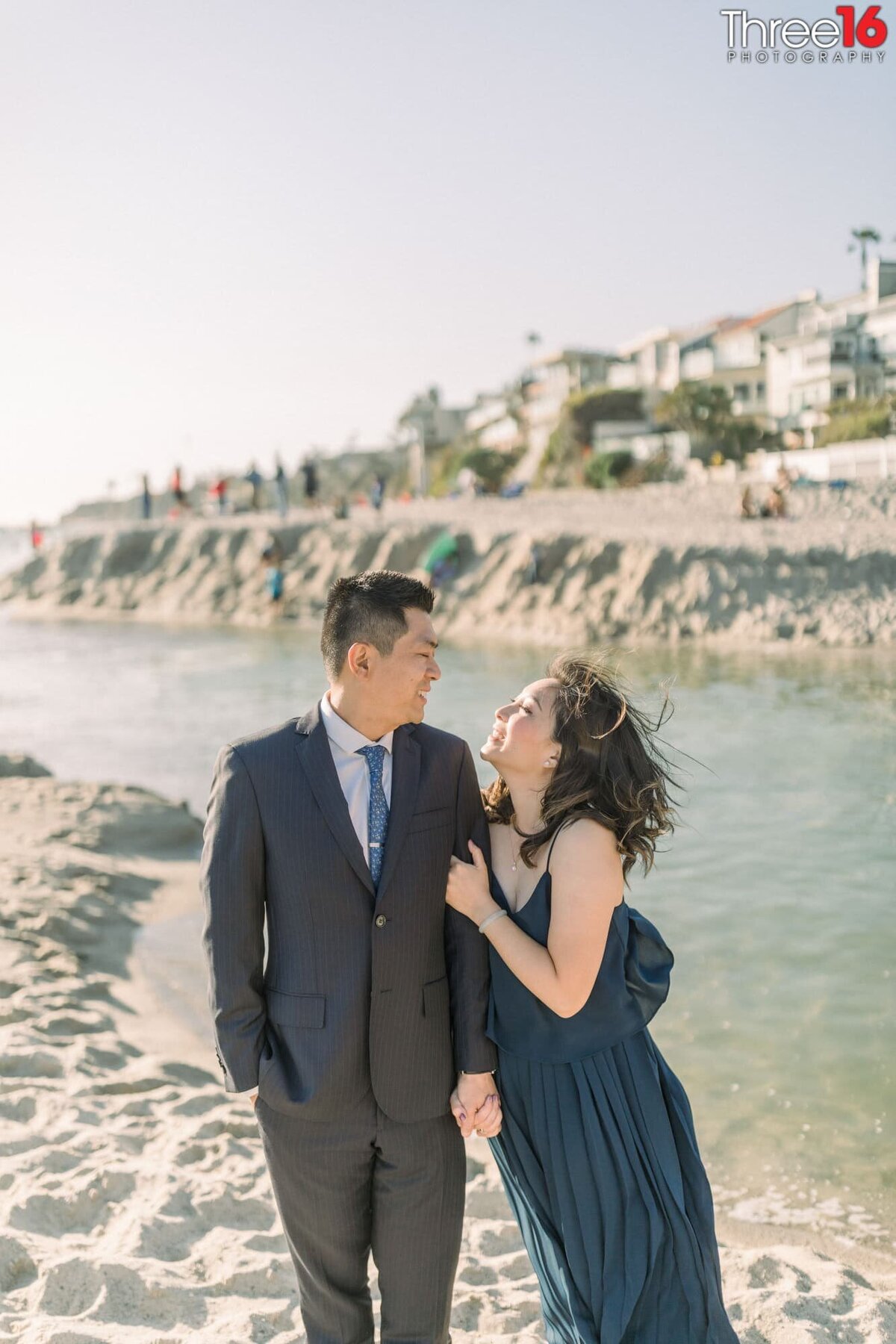 Bride to be leans in to her Groom with a big smile on Aliso Beach