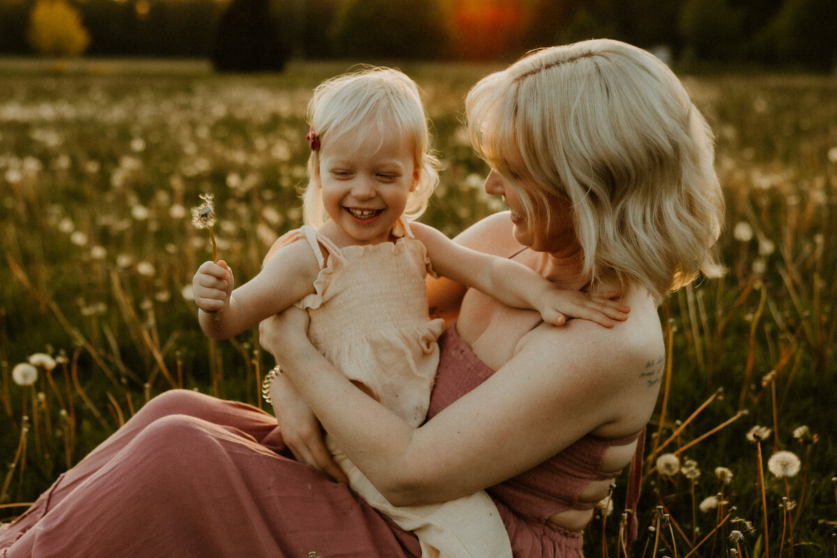 motherhood photo of mom and daughter sitting outside during lifestyle photoshoot