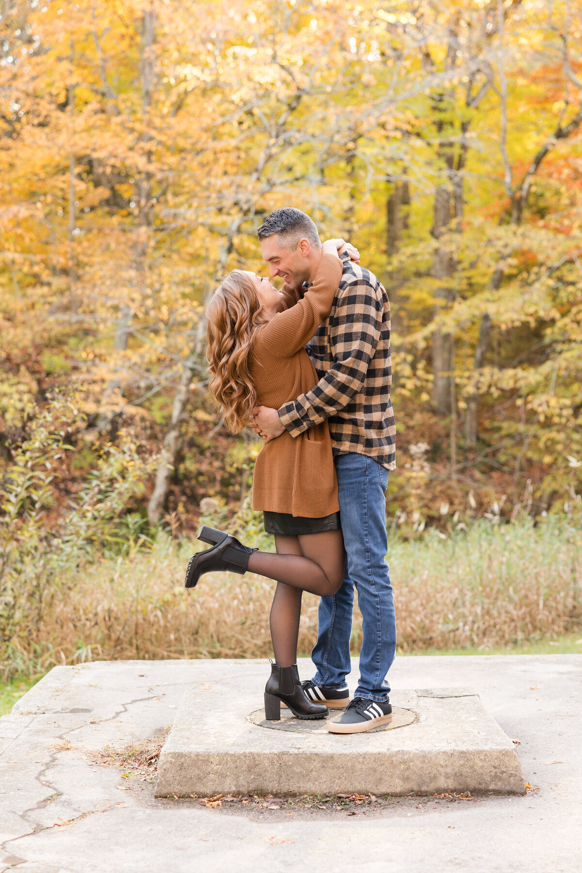 A couple is holding each other and smiling at one another