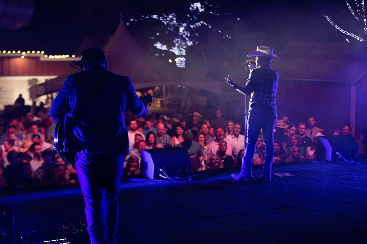 Country singer performing on outdoor stage at night