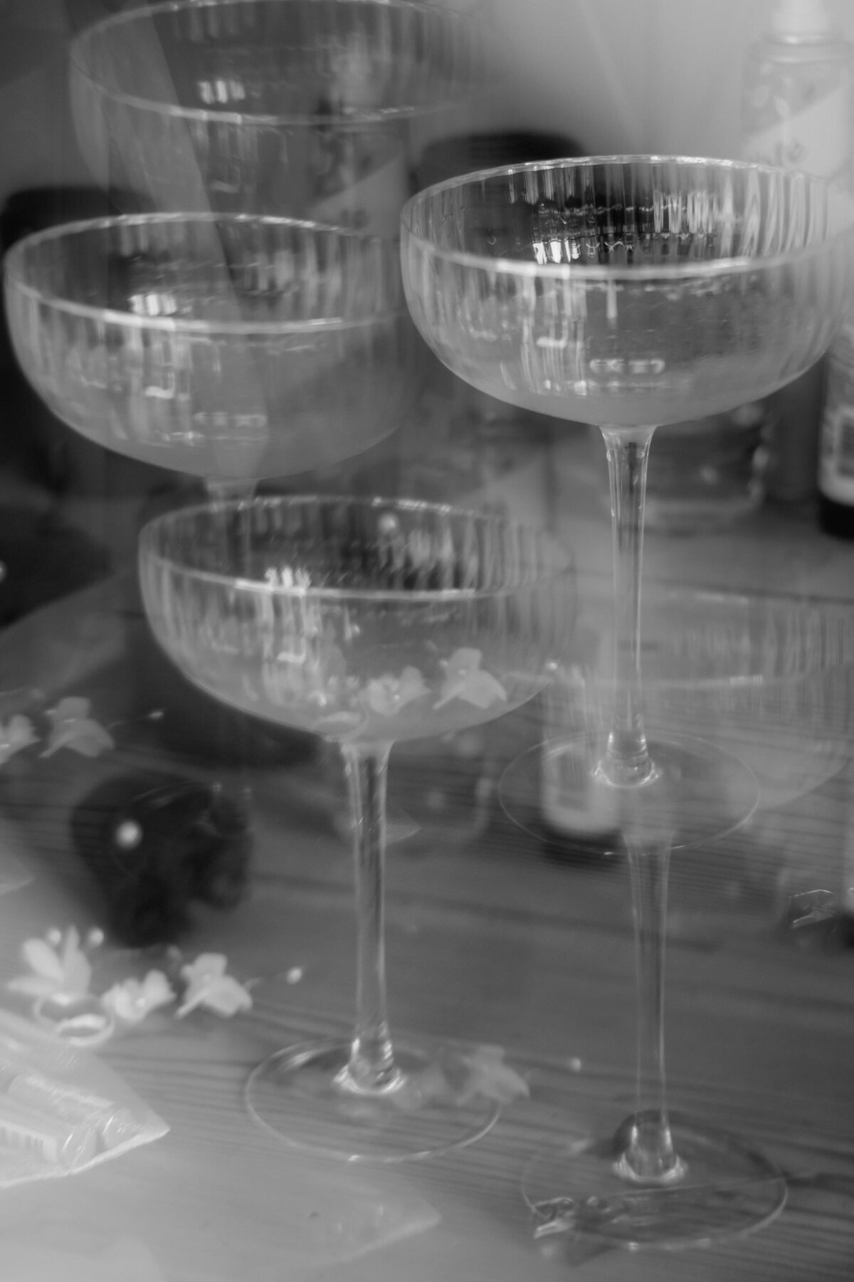 Durch ein Glasprisma wird das auf einem Tisch stehende Champagnerglas künstlerisch gespiegelt.