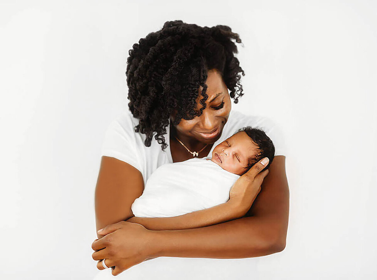 New mother cradles her infant during Newborn Photoshoot in Asheville, NC.