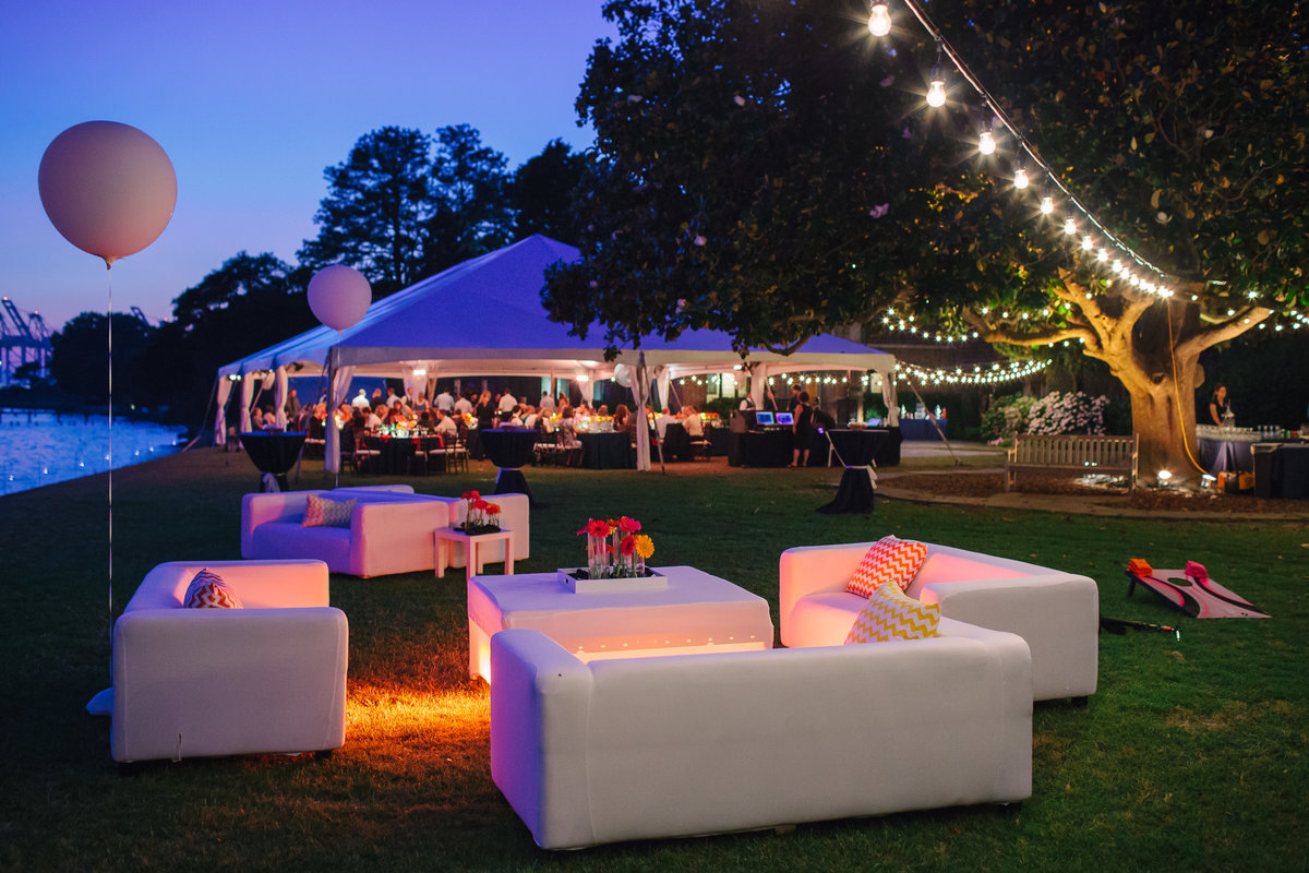 Bistro lights and specialty furniture create sophisticated ambiance at wedding