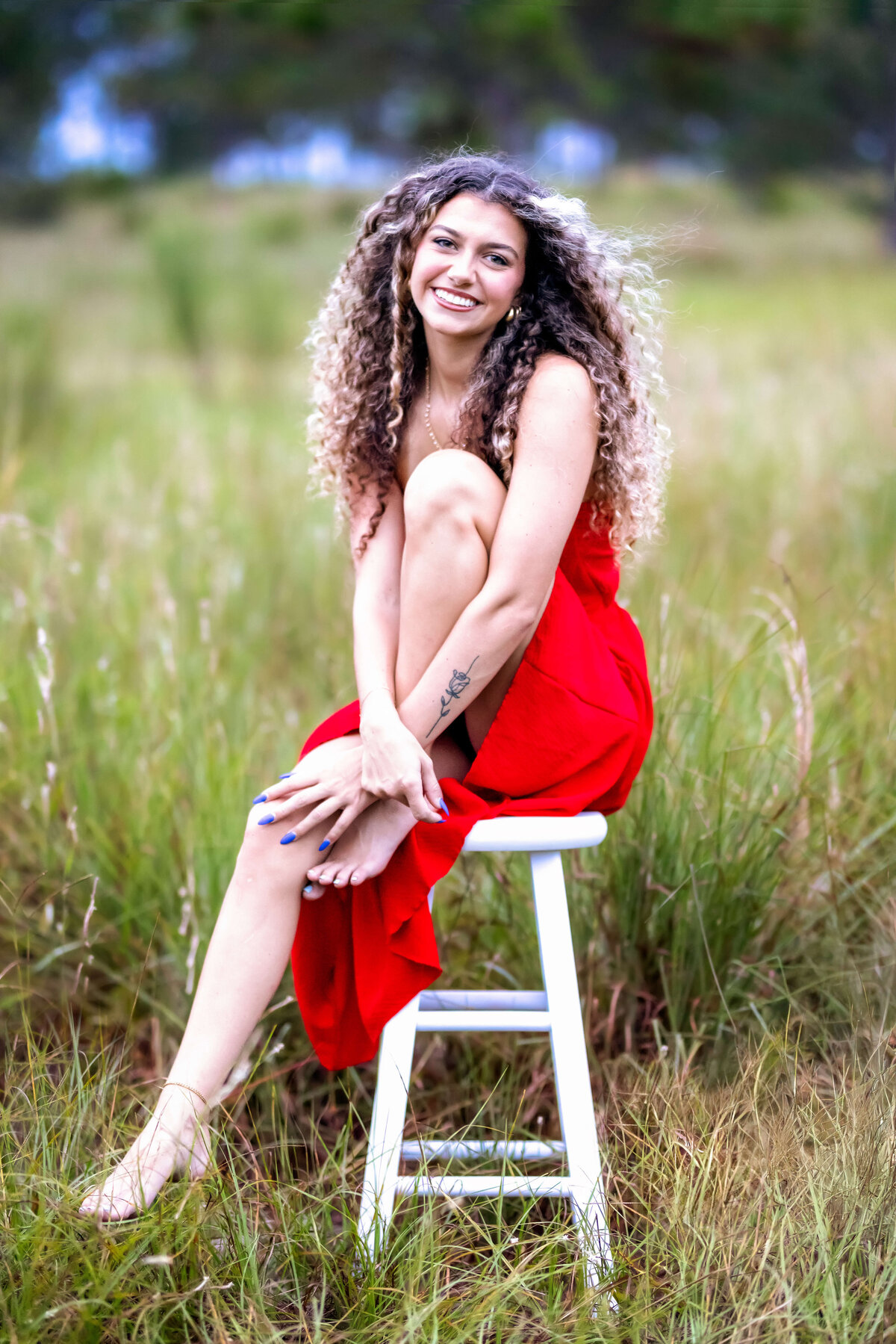 Elegant Winter Garden senior portrait featuring a teen girl posing in a bold red dress.