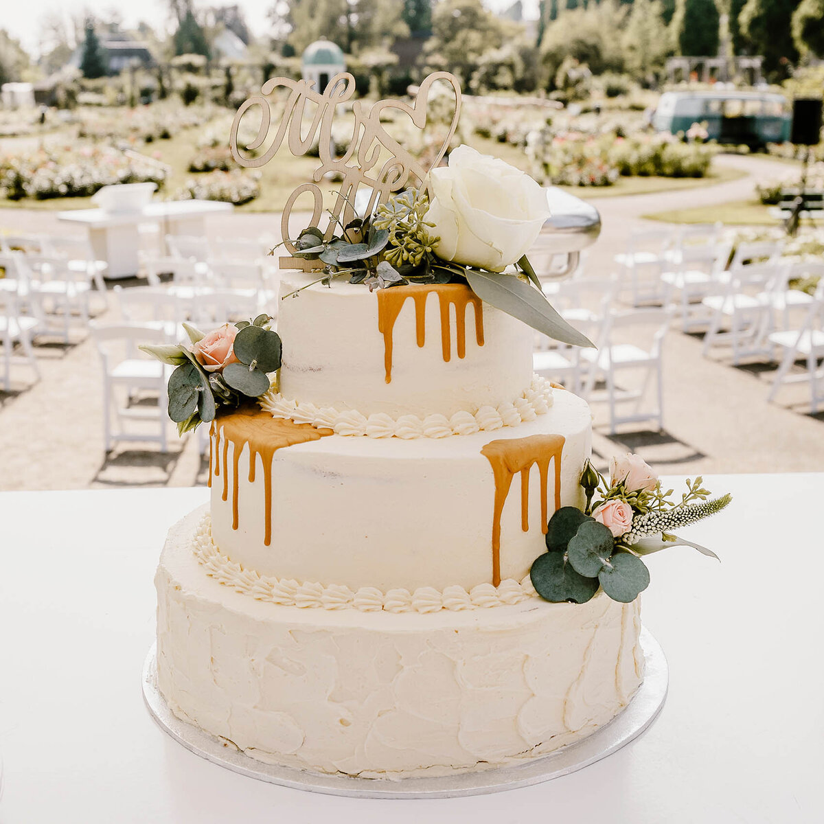 Bruidstaart van Berg's Bakery met drip en bloemen.
