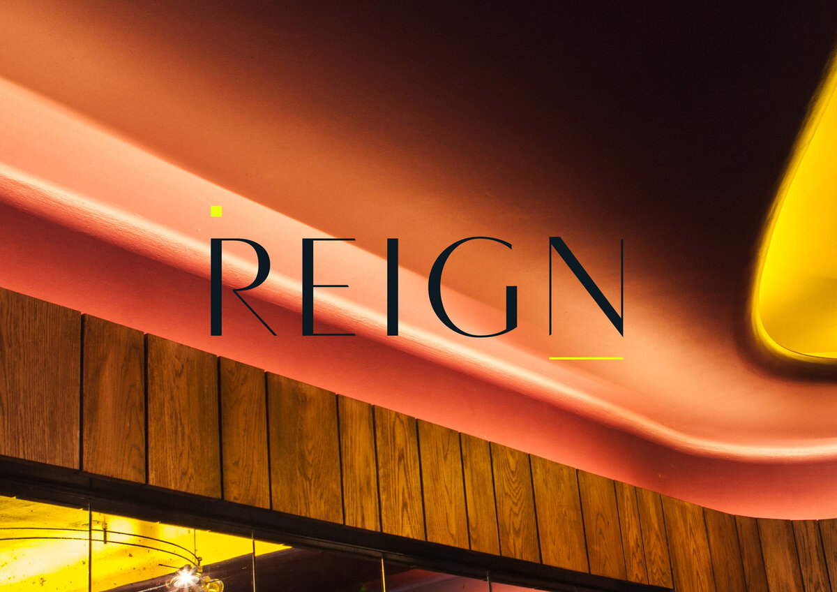 Reign custom primary logo design with neon accents overlaid on interior design image.