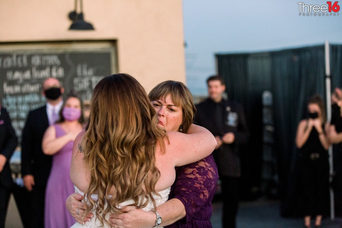 Bride receives a hug from her mother at the wedding ceremony