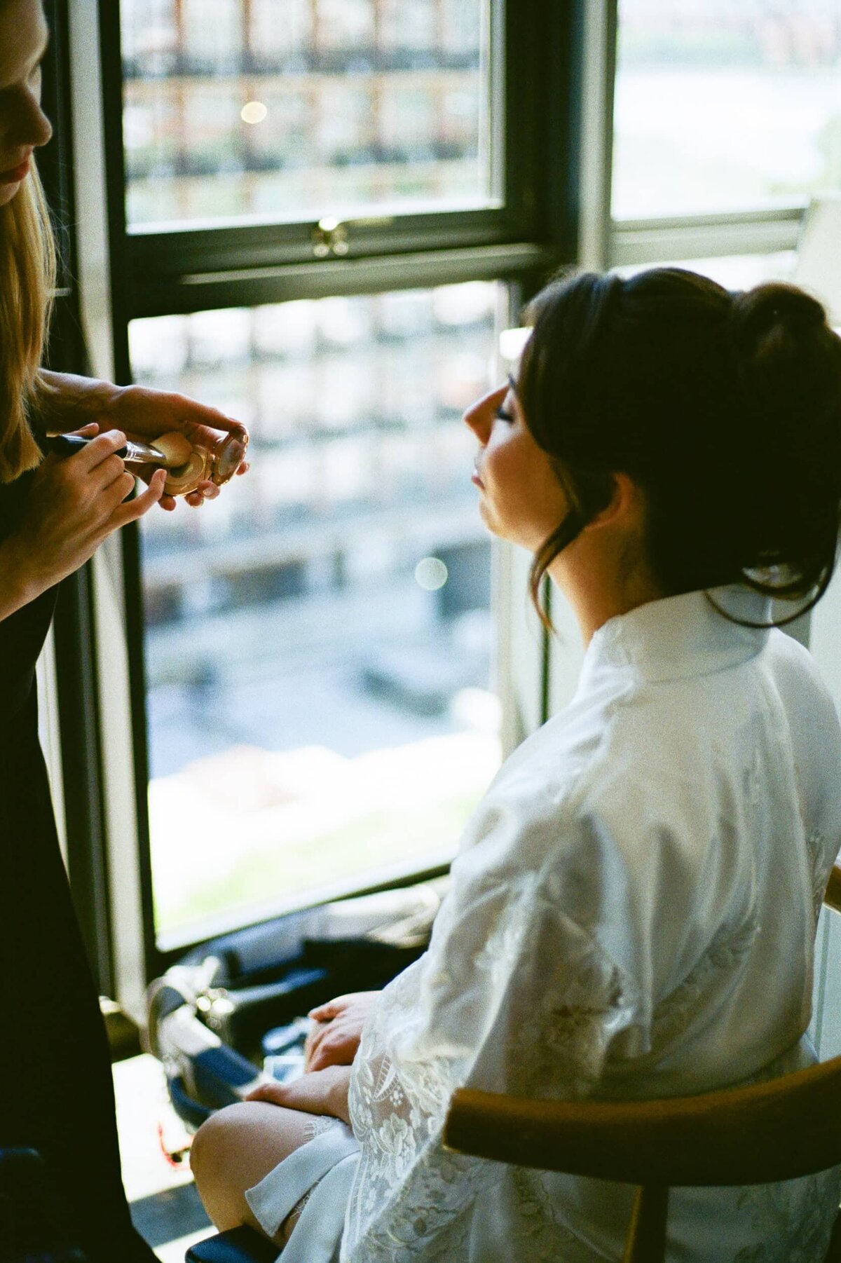 bride getting makeup done at the wythe hotel photographed in 35mm film