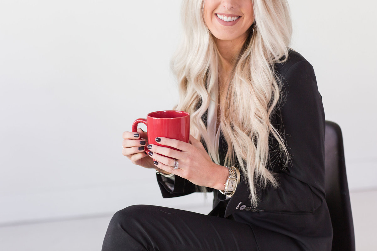 Female entrepreneur holding a red coffee mug