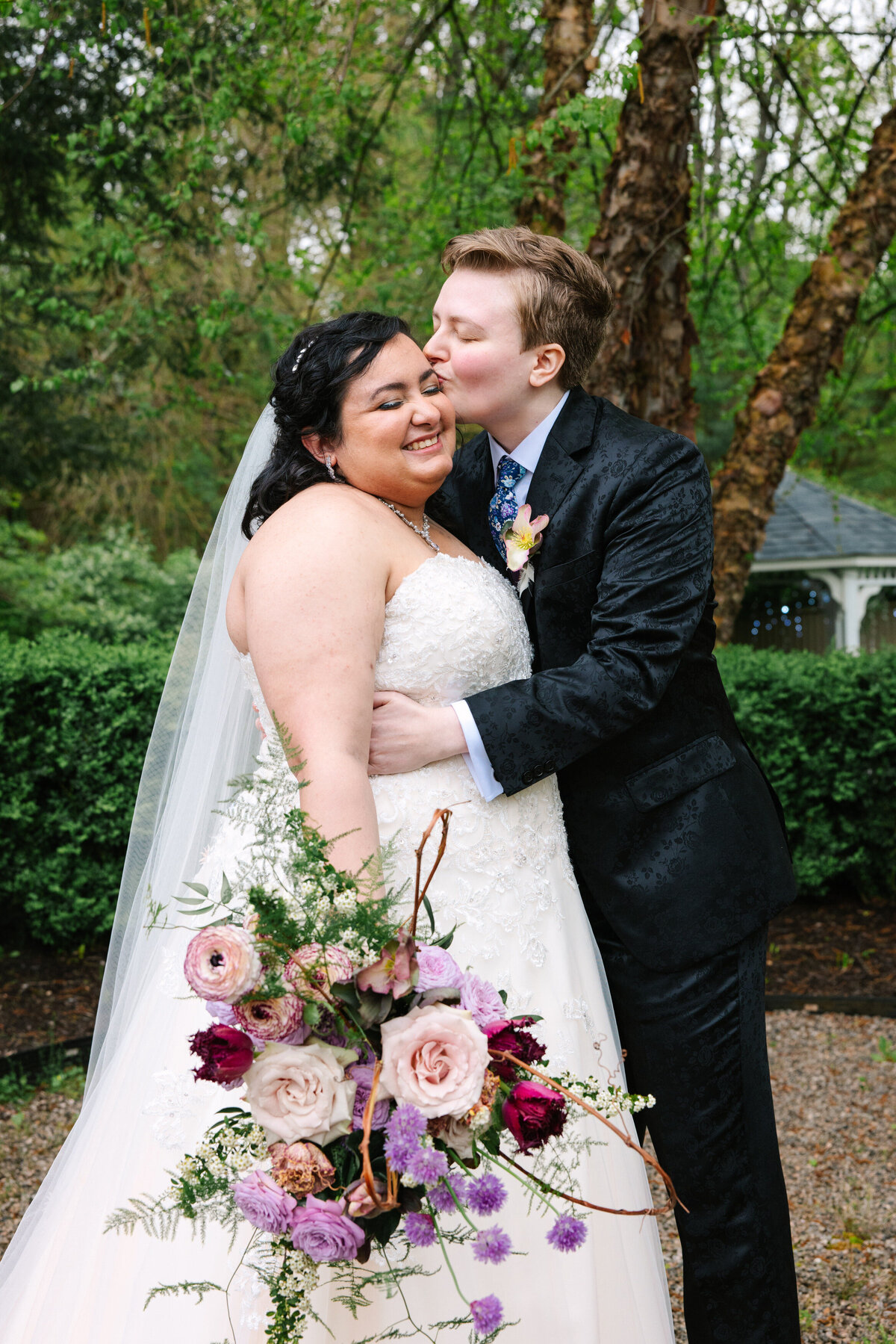 Bride in suit kissing bride in dress