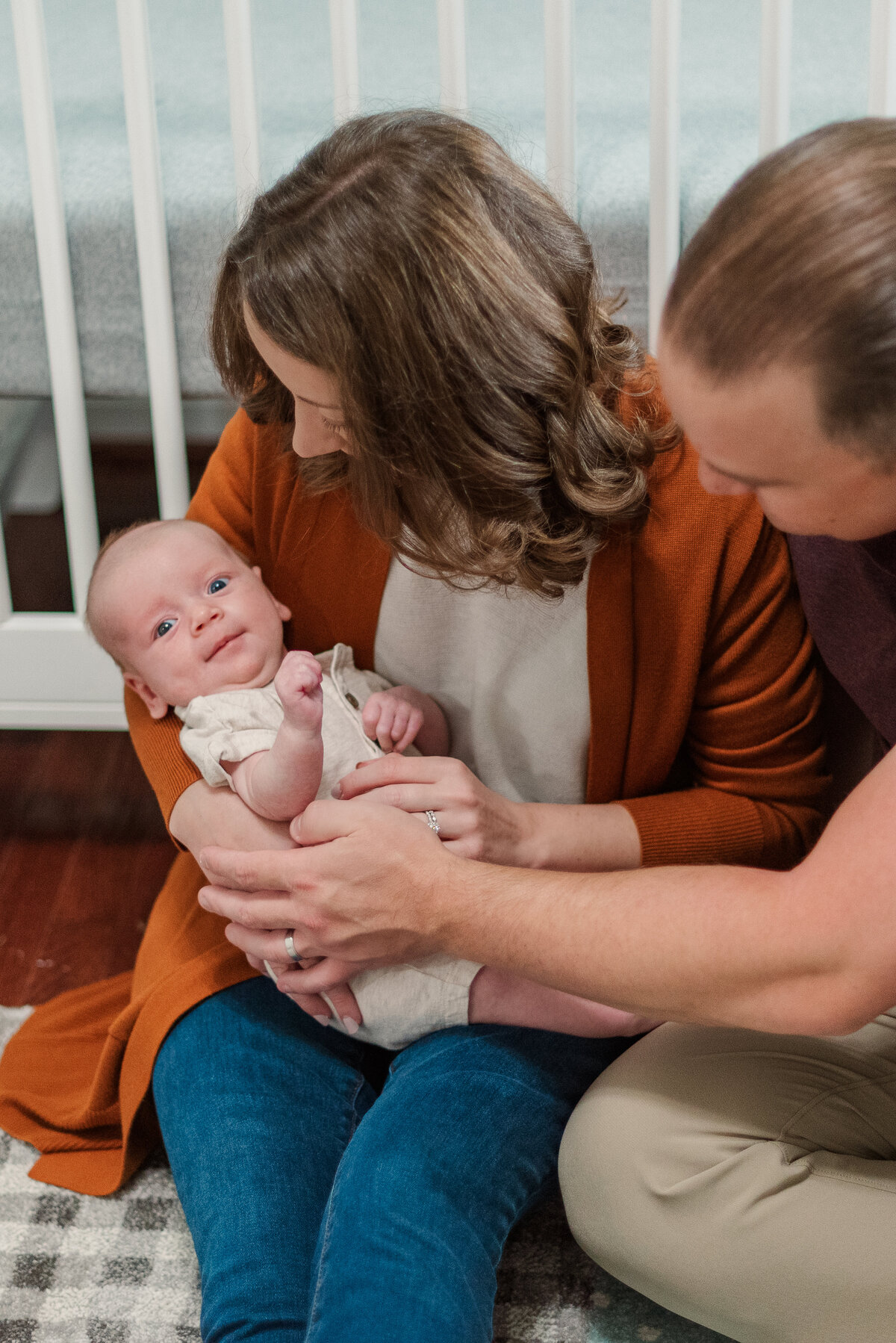 parents sitting on floor with newborn photographers baltimore md