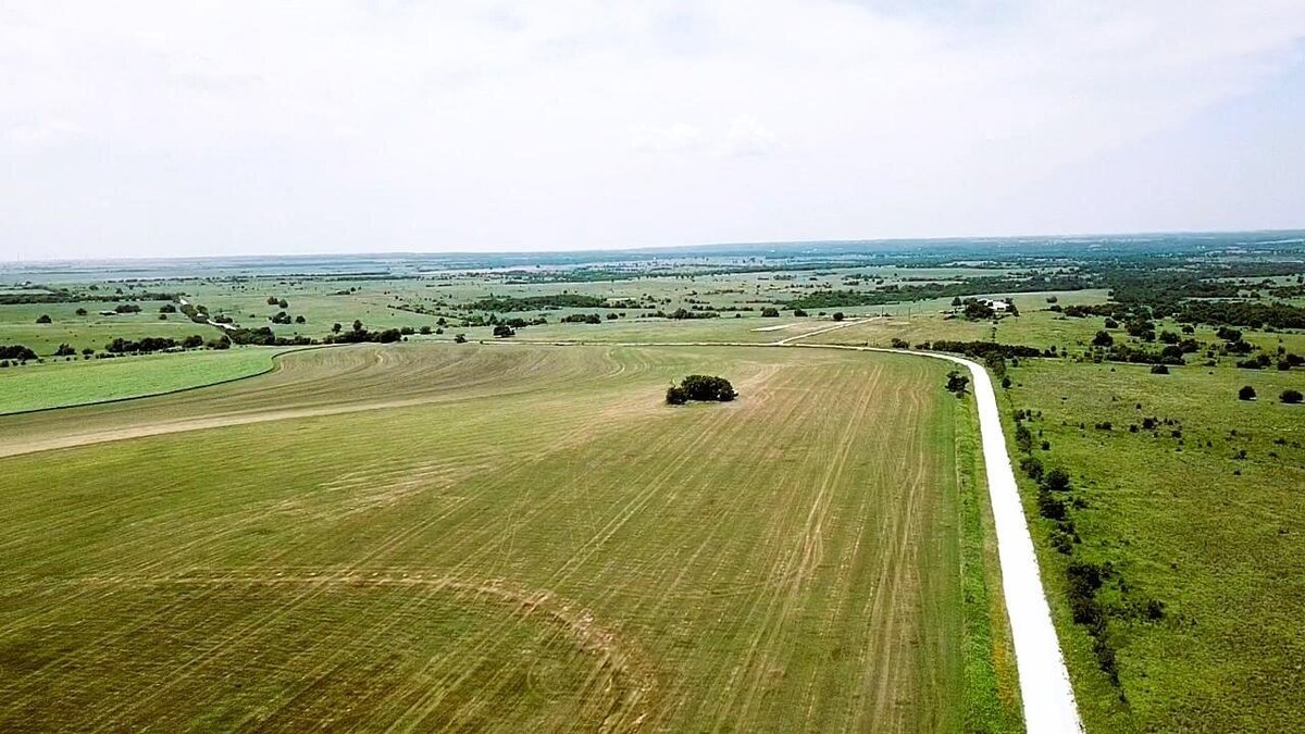 Aerial view of 11-acre property in Lindsay, Texas with open fields and clear skies