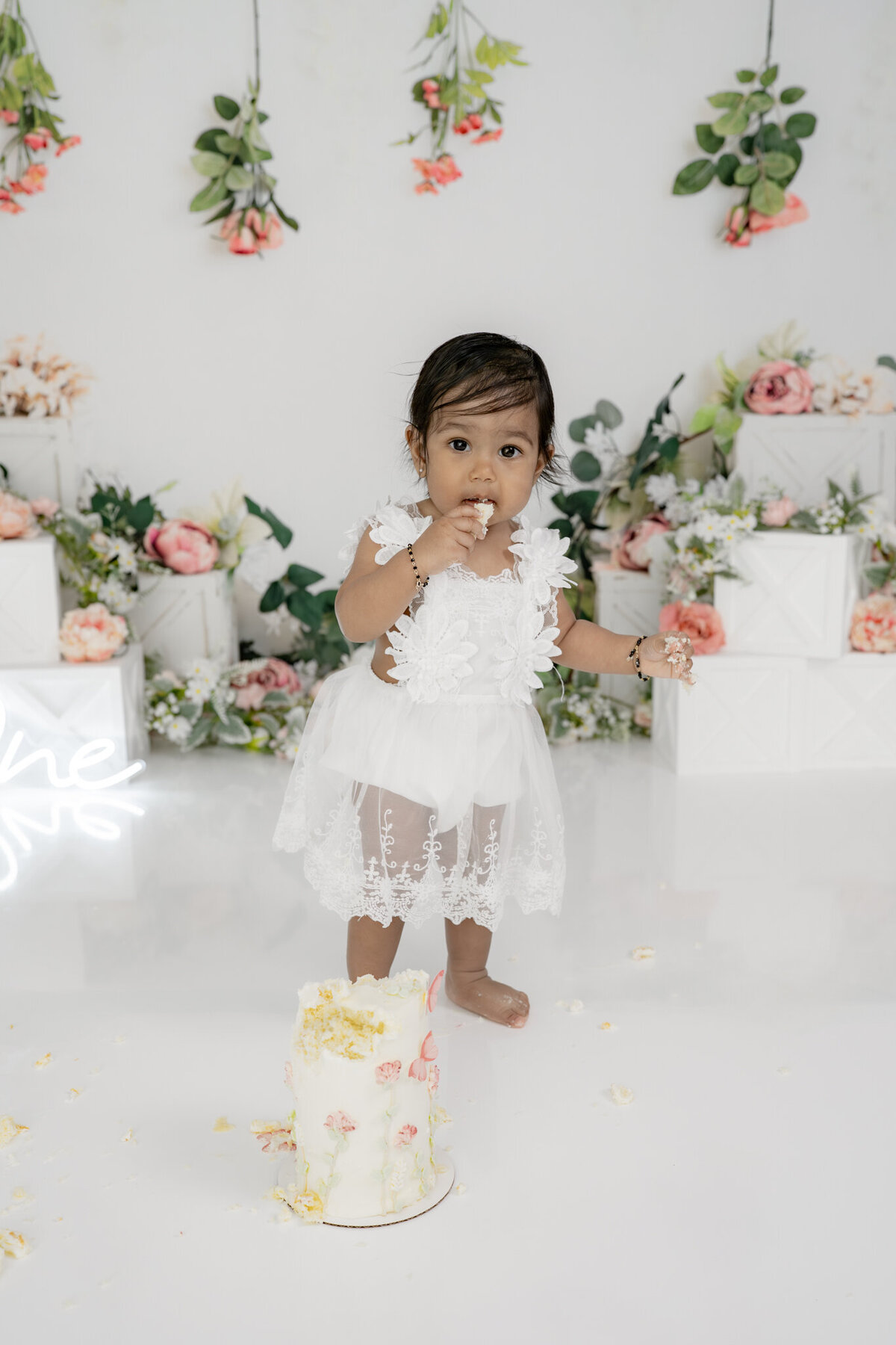 Girl eating cake during floral themed cake smash session— captured by Alliston and Barrie cake smash photographer.