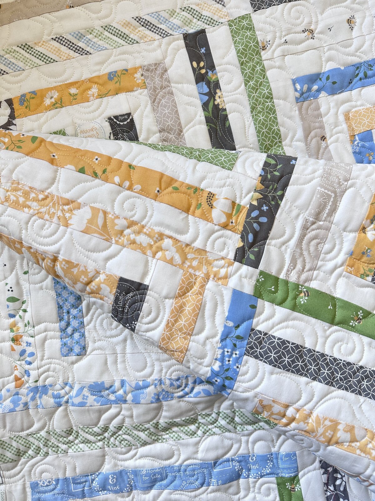 This white, yellow, green and blue quilt features the hibiscus quilting design