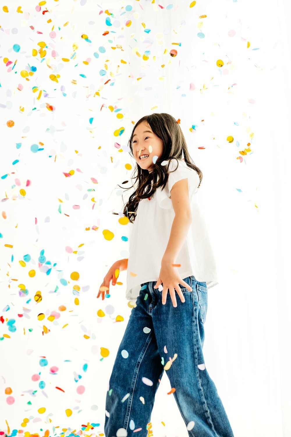 girl watches confetti falling all around her