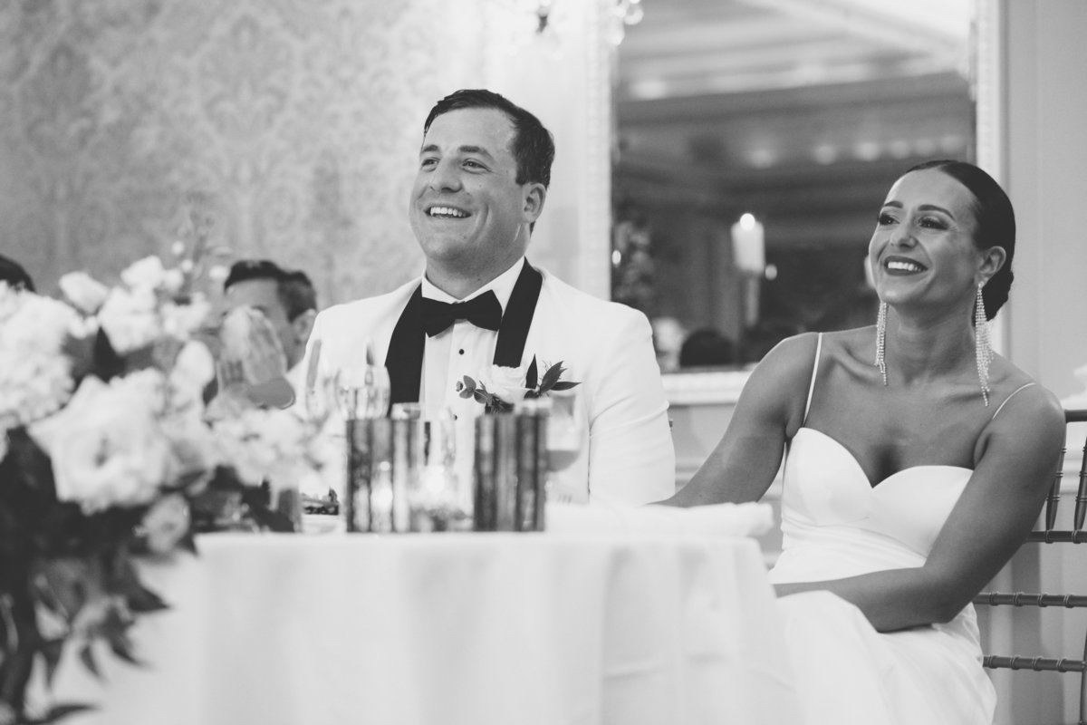 black and white photo of bride and groom laughing during wedding reception at The Muttontown Club