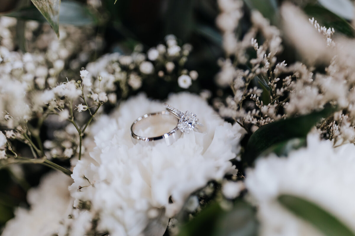 Nashville wedding photographer captures close up of bridal bouquet with wedding rings in flowers