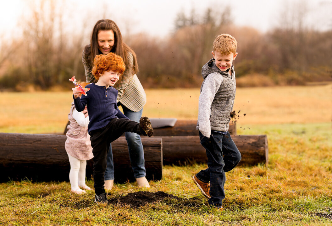 Little boy kicks dirt at his brother during a playful family photoshoot session in Snoqualmie WA.