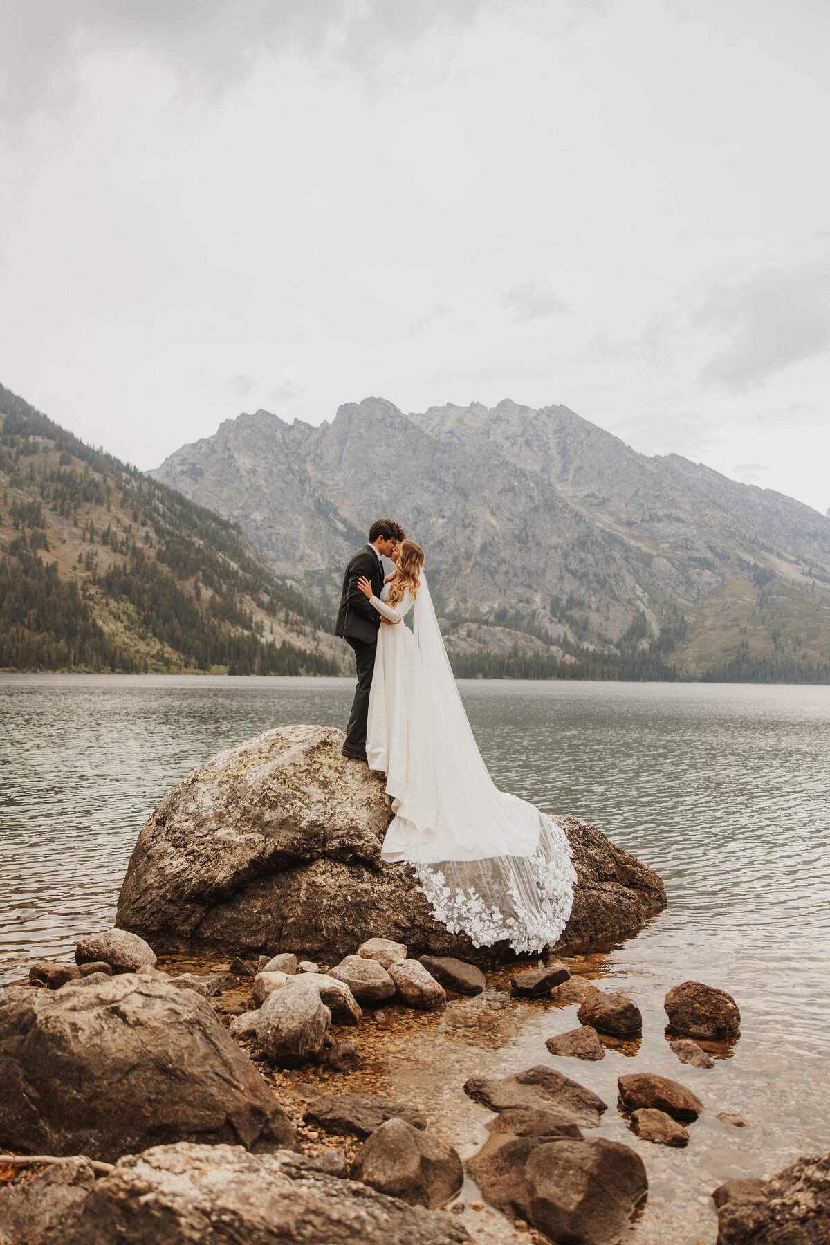 bride and groom kissing in lake