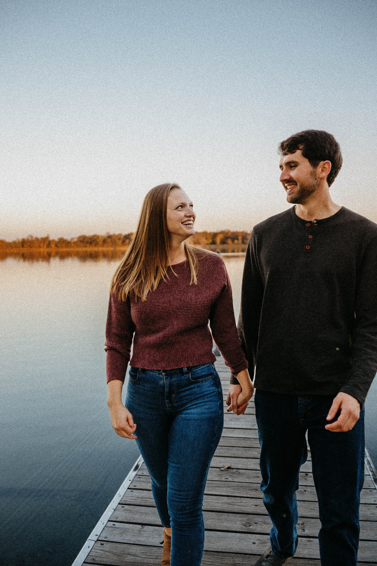 engaged-couple-walking-by-lake