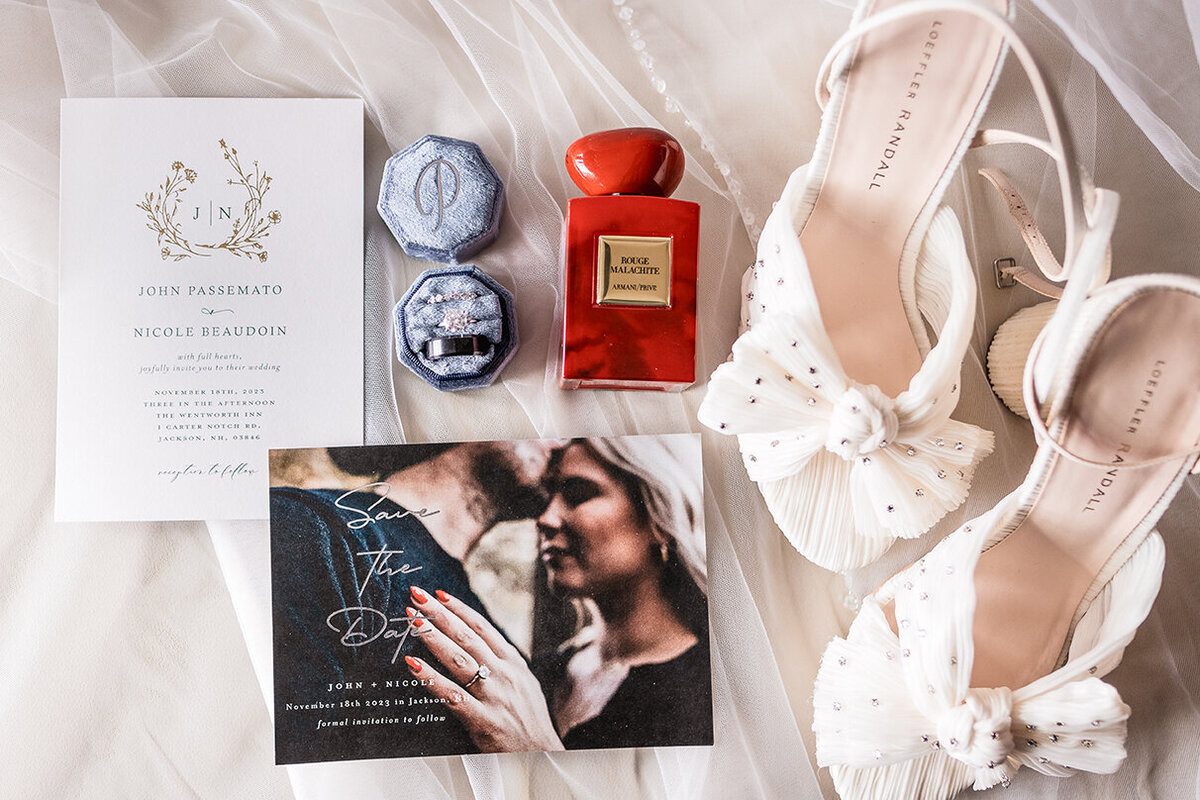 Flat Lay of wedding invitation, save the date, vail, wedding shoes, rings and perfume at Wentworth Inn in Jackson NH