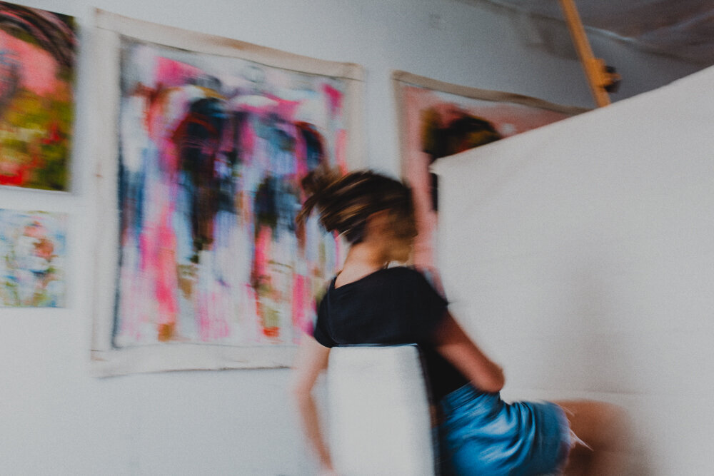 a woman moving around in her art studio