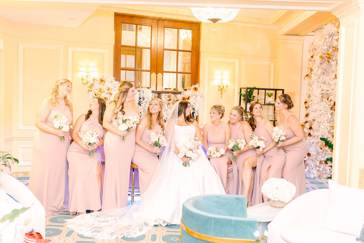 Bride with bridesmaids in blush pink dresses before ceremony