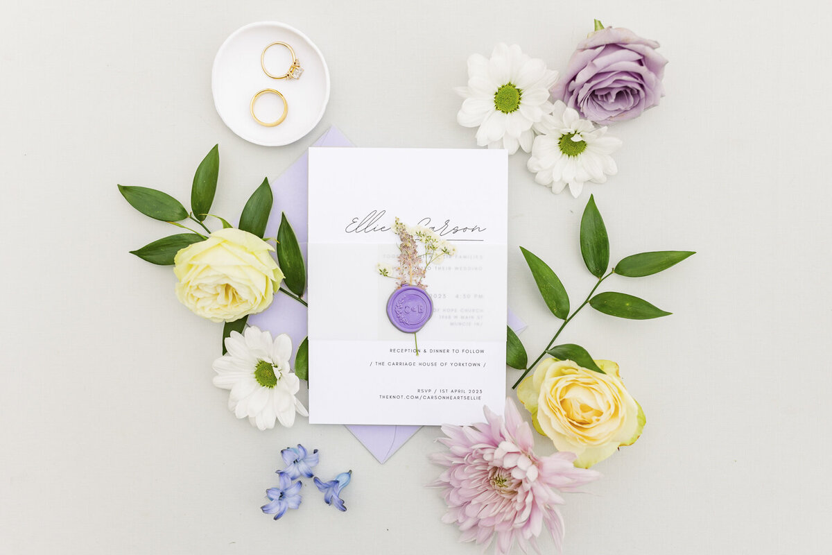 flat lay of colorful flowers and wedding stationery