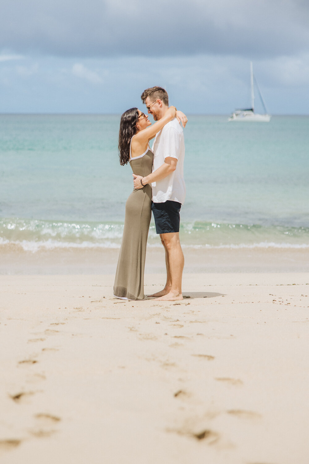 couple on beach with footprints leading to them