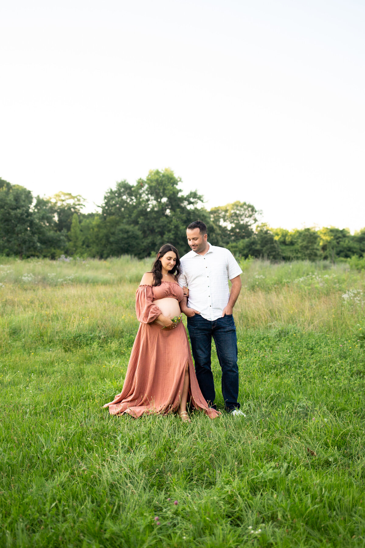 couples maternity session in wildflower field