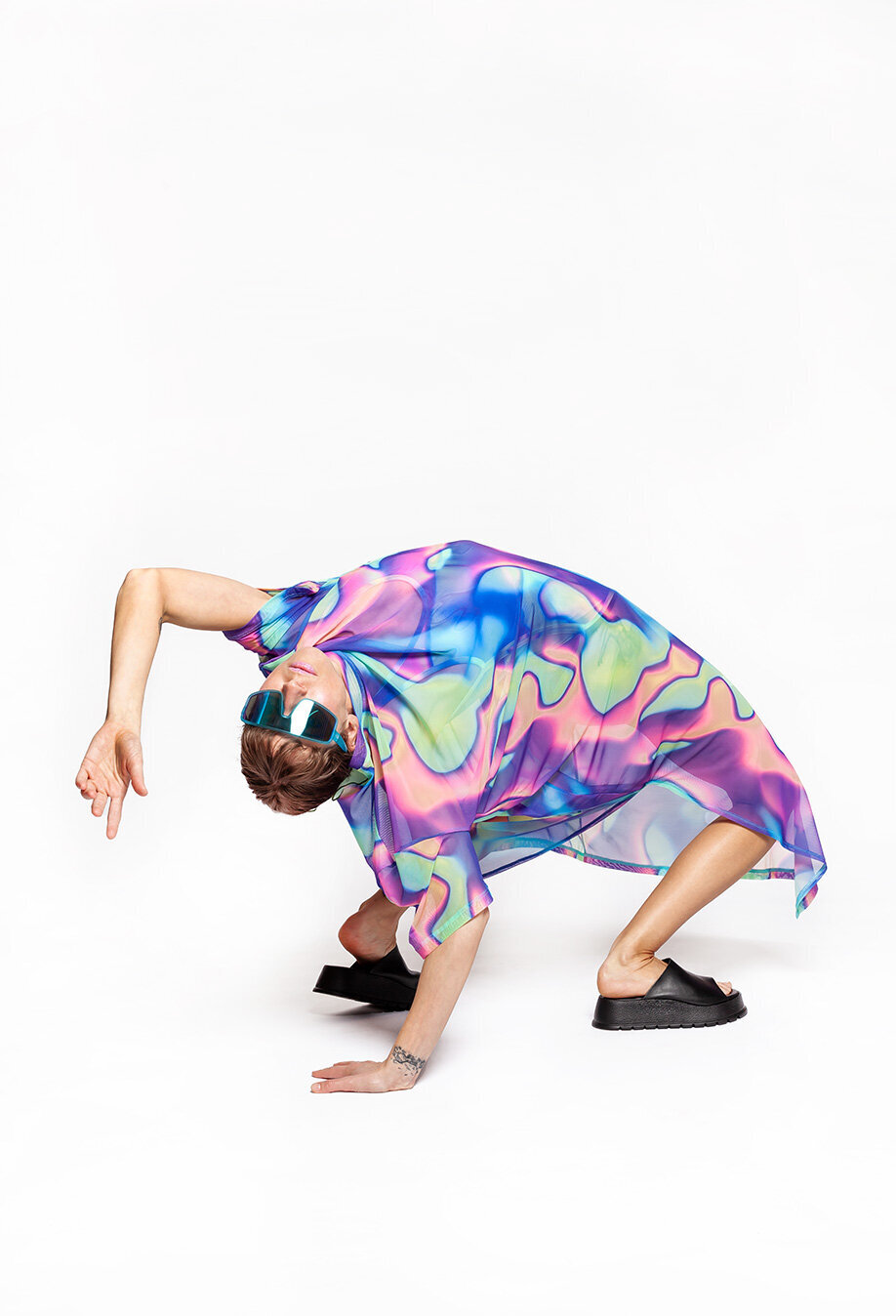 Josefine sitting in a squat pose, smiling at the camera with a calm and joyful expression.