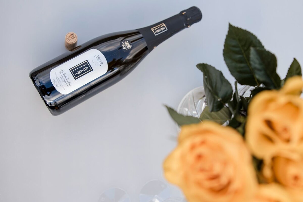 Champagne bottle and yellow roses.