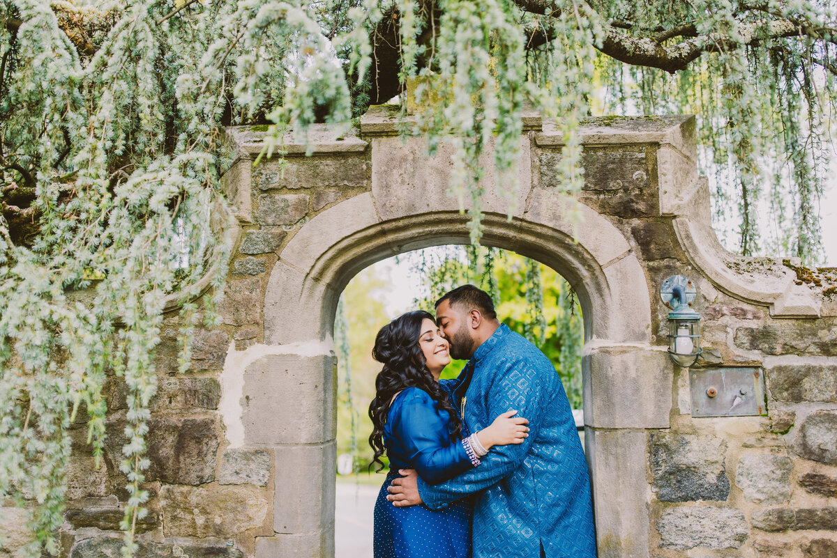 A couple kissing under an arch at the skylands manor in ringwood state park in nj