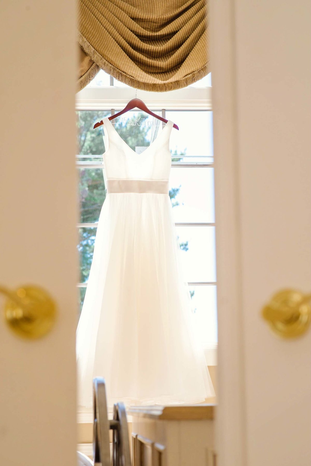 Bride's dress haning in the window at Stonebridge Country Club